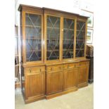 A reproduction mahogany breakfront bookcase, having four astragal-glazed doors, four waist drawers