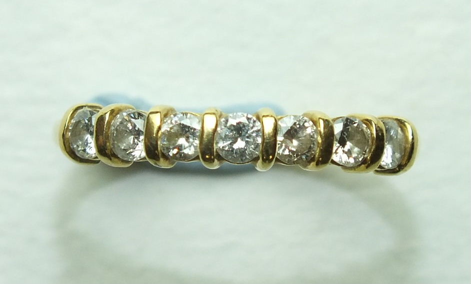 A diamond half-hoop ring set seven brilliant-cut diamonds, in 18ct yellow gold mount, size P, 2.4g.