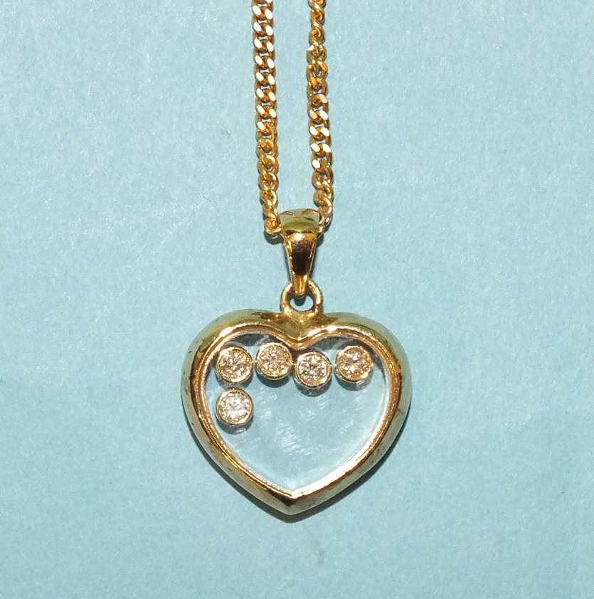 A 'floating' diamond pendant of heart shape with five collet-set diamonds, the mount marked "9k", on