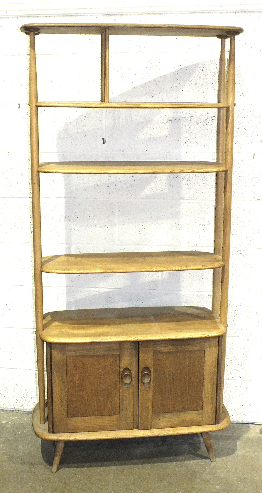 An Ercol light elm 'Giraffe' room divider fitted with three shelves, (two adjustable), above a