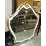 A painted white and gilt shaped wall mirror, 101cm high, 90cm wide.