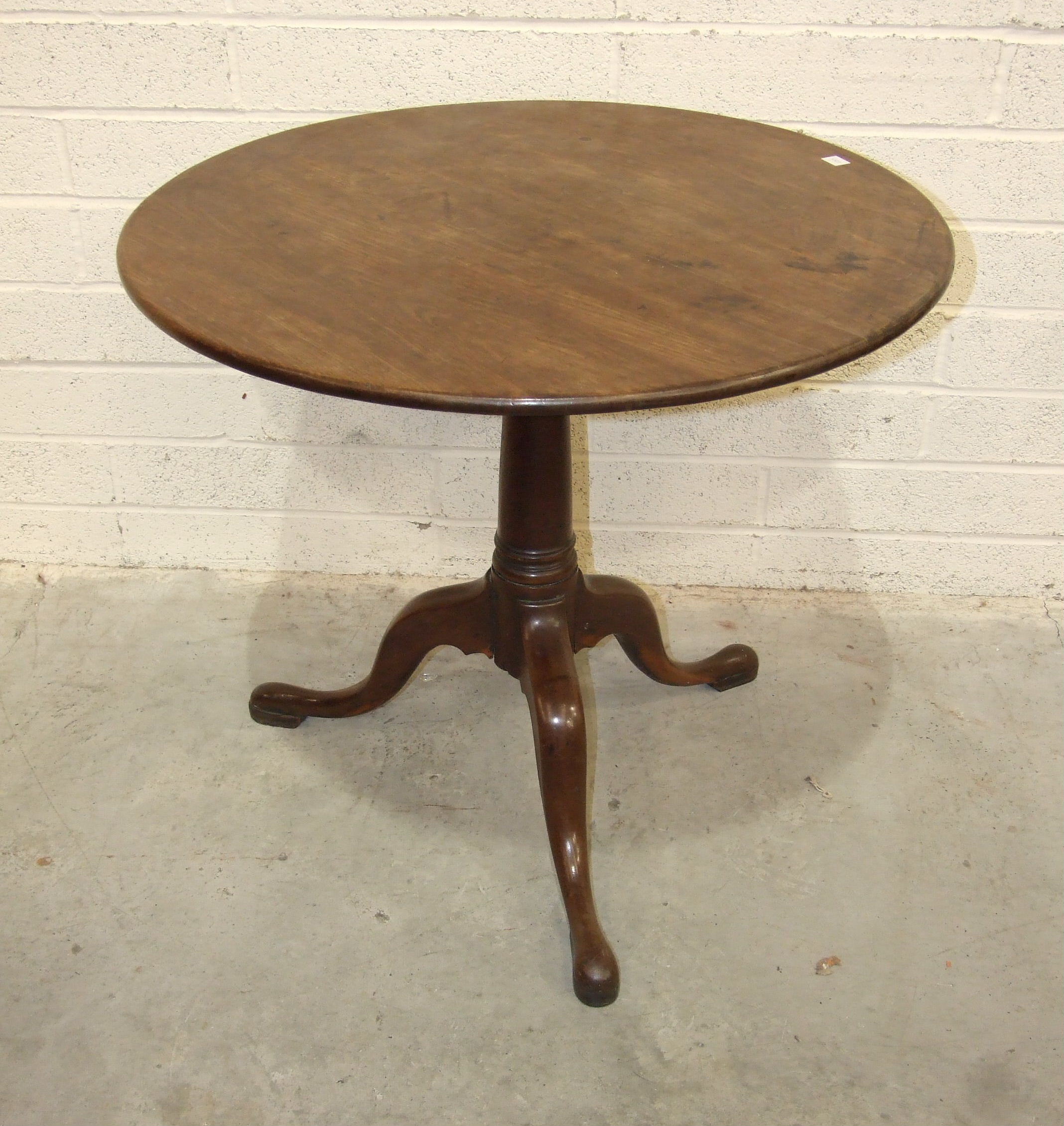 A Georgian mahogany circular tilt-top occasional table with plain stem and tripod support, on pad