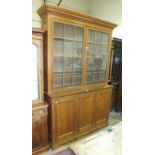 An early-20th century large oak bookcase, the dentil cornice above two leaded-light glazed doors and