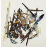 A collection of various wooden lace-making bobbins and other related items.