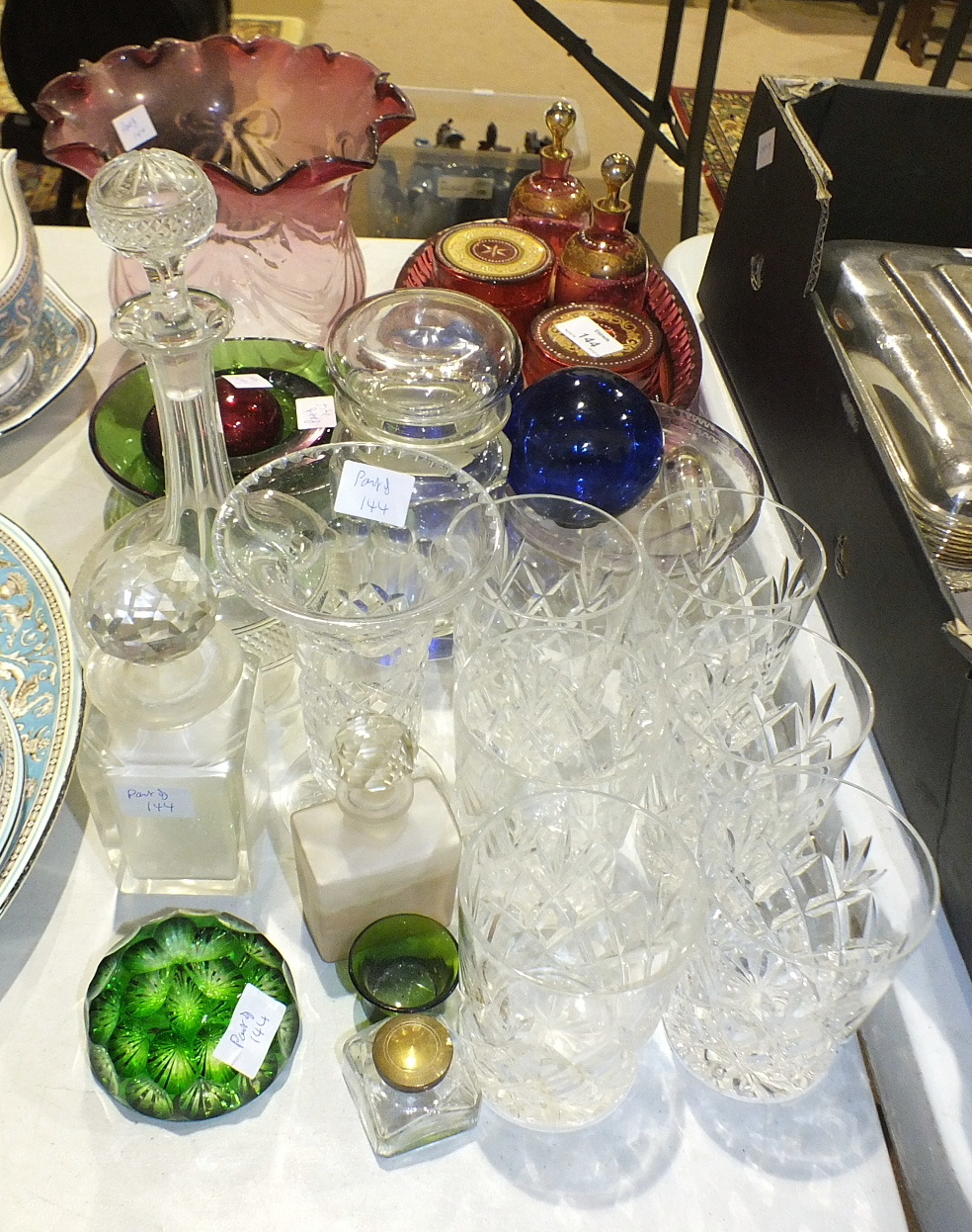 A four-piece cranberry glass dressing table set, on oval tray with white enamel and gilt decoration,