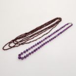 Konvolut aus 2 Steinketten: 1 Collier aus fac. Amethystkugeln im Verlauf (ca. 5,5-9,5mm),