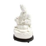 Sitzende "Blanc de Chine"-Guanyin, 19. Jh. in der linken Hand hält sie eine Schriftrolle mit