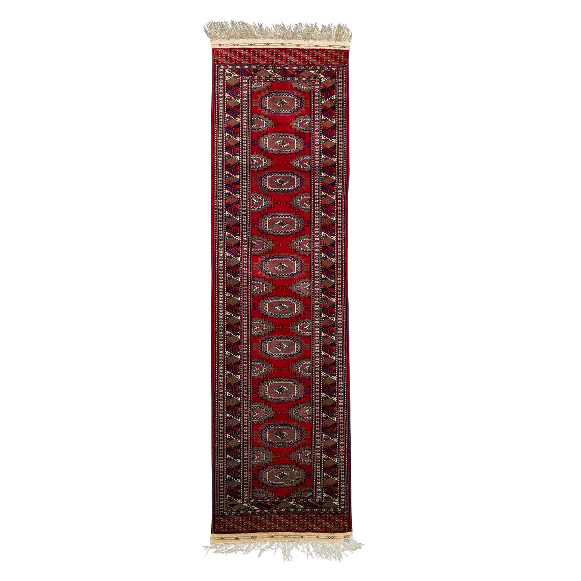 Orientteppich. Galerie, PAKISTAN, 20. Jh., ca. 270x74 cm.Der rote Fond des Innenfeldes zeigt ein