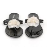 CHANEL edle Zehentrennersandalen. Schwarzes Vinylmaterial mit Camelienblütendetail.