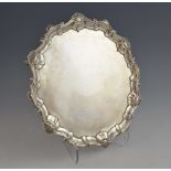 George II silver salver with shell and scroll rim on three hoof feet, by Alexander Johnston, London,