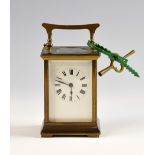 Brass carriage clock with black Roman numerals and white enamel dial, marked for Harrods, London,