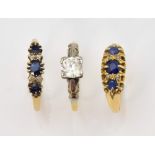Three gold gem set rings, two seven stone sapphire and diamond rings, both size O, and a white topaz