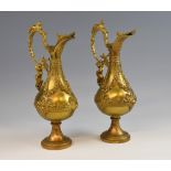 Pair of late 19th century gilt metal ewers cast with figural handles, 38cm high.