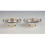 Pair of George V silver dishes with scrolling handles on round feet, by William Hutton & Sons