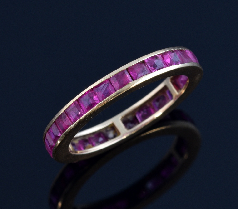 Ruby full eternity ring, set with square cut rubies in a channel setting in yellow metal, tested