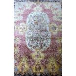 Persian type silk rug with a floral border, the centre with an oval medallion , 186cm x 143cm .