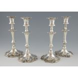 Four George III-style silver-plated candlesticks, the filled bases engraved with two crests,