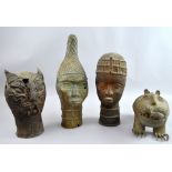 Four Benin-style cast bronzes, two of female heads, a stylised cat and a stylised lion eating a