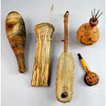 Group of three tribal decorative seed pods, together with a stringed instrument, 53 cm long, (4)