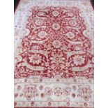 A Red ground Persian type carpet, 316 x 243 cms. very faded throughout, some staining, loss of