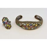 Multi stone set bangle, including rub over set oval cut rubies and paste stones, with scrolling