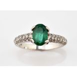 Emerald and diamond modern dress ring, with central oval emerald, of 0.97 carat and pave set diamond