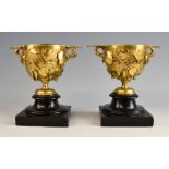 Pair of gilt metal pedestal cups cast with fruiting vines. 18cm high.