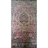 Persian silk pink ground rug, with multiple borders, the centre with repeating floral forms, 172cm x