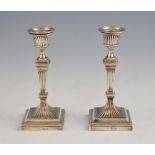 Pair of Edward VII silver candlesticks with fluted columns on square bases, by William Hutton & Sons