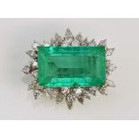 Large emerald and diamond set brooch with step cut emerald of good colour, 12.25 carat, within a