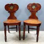 Pair of 19th century mahogany hall chairs with carved backs and painted decoration of a knight