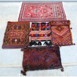 Red ground Persian Rug and a collection of saddlebags .