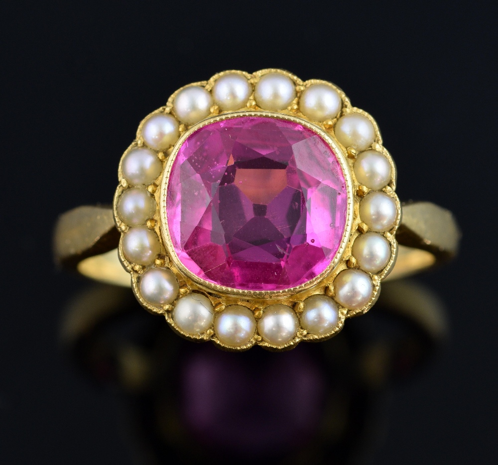 Gold ring set with a pink synthetic sapphire within a border of pearls, central stone estimated at