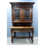 Late 19th century oak cabinet on stand with carved and embossed metal decoration of figures, the