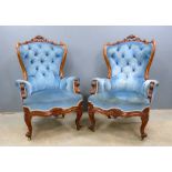 Pair of continental walnut framed and blue upholstered button back armchairs, with carved decoration