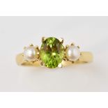 Dress ring set with peridot and pearl in 9 ct gold, ring size O .