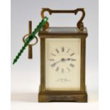 Brass carriage clock with black Roman numerals, on a white enamel dial, four glass sides, marked for