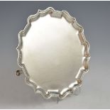 George V silver salver with shaped border on three hoof feet, by C S Harris & Sons Ltd., London,