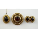 Victorian jewellery with cabochon garnet in ball and rope decorated mounts with white enamel, one