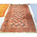 Red ground Afghan rug with multiple borders, the centre with repeating medallions 200cm x 120cm