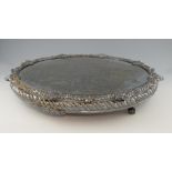 Silver plated circular mirror-plateau, on four claw feet, the border decorated with fruiting flowers