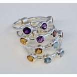 Gemstone set stacking rings, four individual rings connected together, each set with three round cut