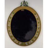 A gilt brass frame, incised and decorated with enamelled flowers, the top with stylised monogram,