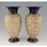 A pair of large Doulton stoneware vases with floral decoration on a gilt ground, 31 cm .