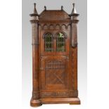 German oak single door cabinet with pitched top and turrets, arched windows with stained glass,