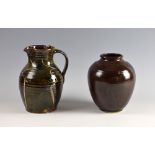 Yelland Studio pottery jug with slip decoration and strap handle and a brown glazed vase, marks to