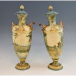 A pair of Royal Doulton vases and covers, decorated with landscape scenes, with swag and mask detail