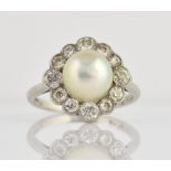 Diamond and pearl ring, with central half pearl and a border of old cut diamonds set in platinum,