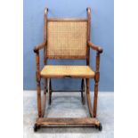 19th century oak wheelchair with caned back and seat, 110cm high .