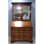 George III mahogany bureau bookcase, the top with two mirrored doors, the fall front with fitted